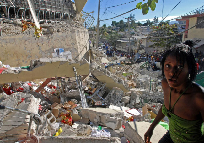 Une jeune femme erre, hagarde, au milieu des ruines à Port-au-Prince, le 13 janvier 2010. La veille, un séisme d'une magnitude de 7,3 sur l'échelle de Richter a ravagé la capitale d'Haïti, faisant plus de 200 000 morts et autant de blessés. Une jeune femme erre, hagarde, au milieu des ruines à Port-au-Prince, le 13 janvier 2010. La veille, un séisme d'une magnitude de 7,3 sur l'échelle de Richter a ravagé la capitale d'Haïti, faisant plus de 200 000 morts et autant de blessés.